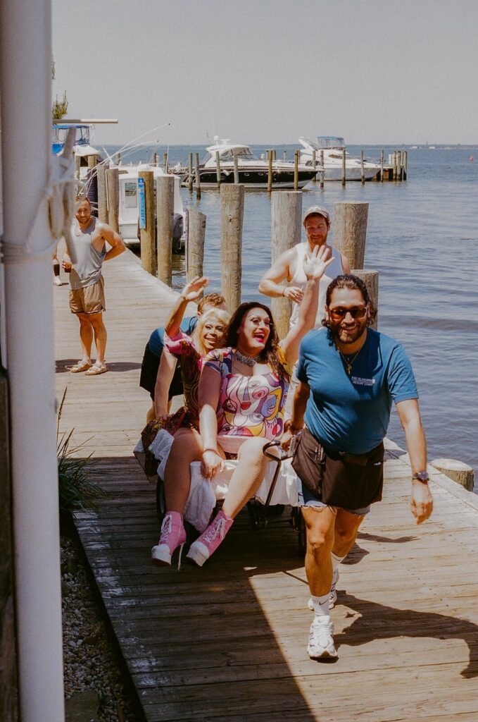 Drag queens arriving at the Fire Island Pines harbor dock with friends on a sunny summer afternoon.