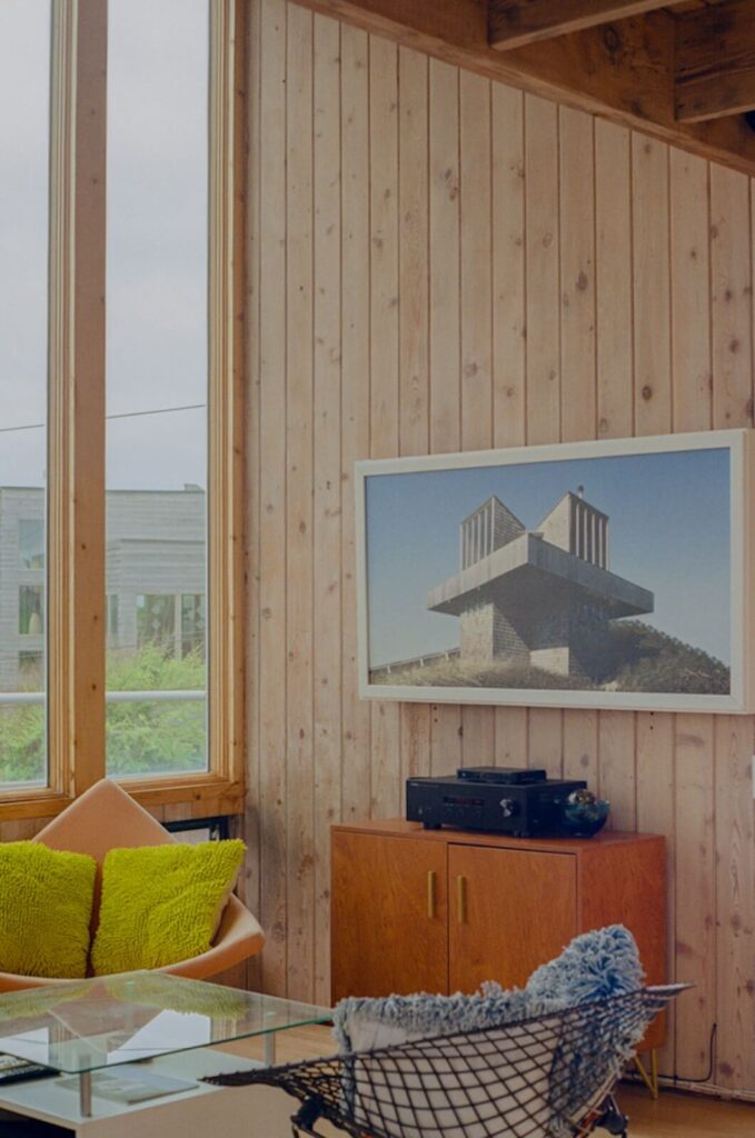 Minimalist modern interior of the Kodak House, a Fire Island Pines beach house with wood panel walls and large windows.