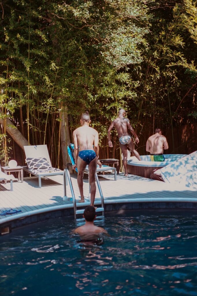 Friends gathered around a backyard pool in Fire Island Pines during a summer afternoon.