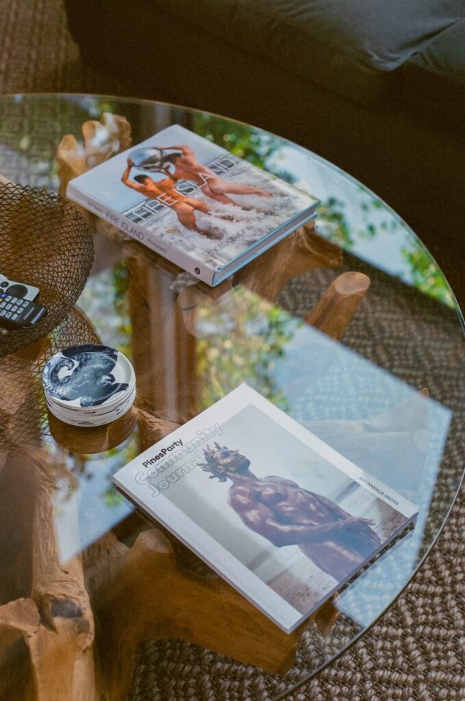 Fire Island photography books resting on a glass coffee table in a Fire Island Pines beach house.